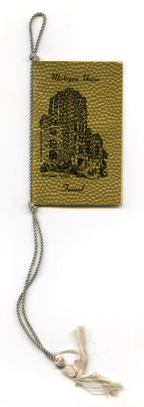 Pebbled gold cover printed with illustration of Union building in black. Silver cord and tassel. 
