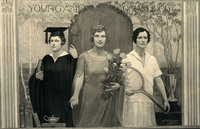Three light-skinned young women; woman on the left wears academic robes and mortarboard and the one on the right wears tennis clothes. The woman in the center holds a bouquet in one hand and reaches out to the viewer with the other.